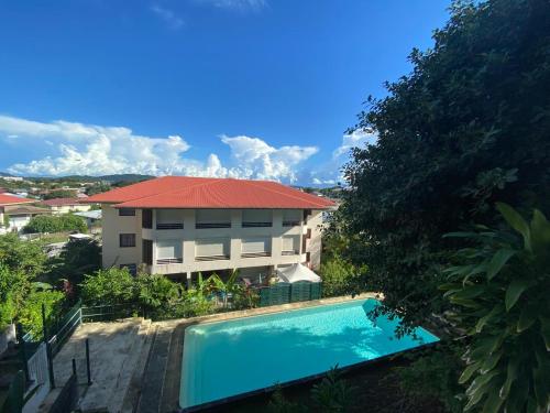 een gebouw met een zwembad voor een huis bij T2 lumineux au calme in Cayenne