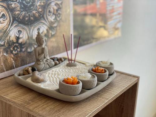 een dienblad met eten op een tafel met een boeddhabeeld bij T2 lumineux au calme in Cayenne