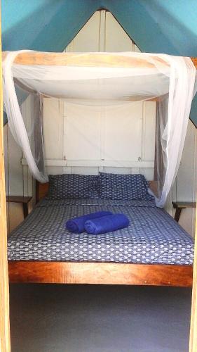 a bunk bed with a blue pillow on it at Cabanas Rusticas in Las Peñitas
