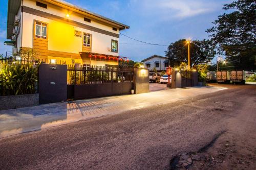 a house with a fence on the side of a street at Value Inn Homestay in Butterworth