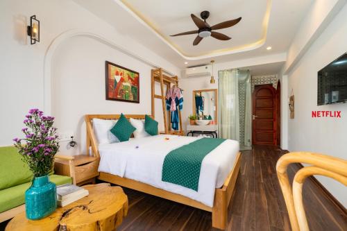 a bedroom with a bed and a table at An Nhien Boutique Villa in Hoi An