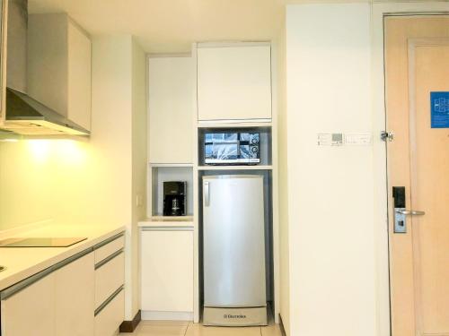 a kitchen with a refrigerator and a microwave at 163 KLCC by Plush in Kuala Lumpur