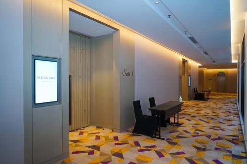 a hallway with a table and chairs in a building at Mercure Kuala Lumpur Glenmarie in Shah Alam