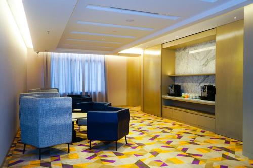 a waiting room with blue chairs and a table at Mercure Kuala Lumpur Glenmarie in Shah Alam