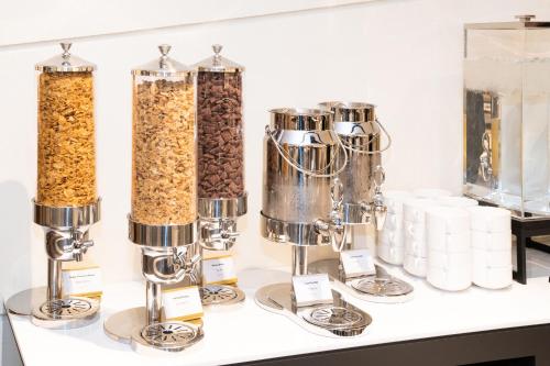 a counter with three containers of cereal and other food items at voco Seoul Gangnam by IHG in Seoul