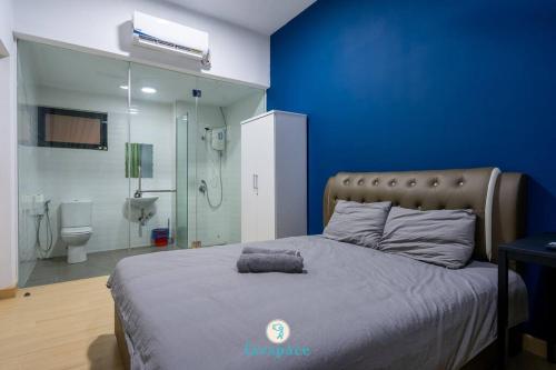 a bedroom with a large bed with a blue wall at Lovely 4-bedroom condo with pool for 6 pax - Cheras in Kuala Lumpur