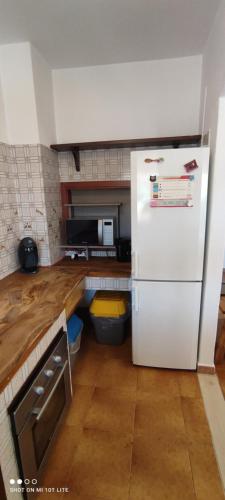 a kitchen with a white refrigerator and a wooden floor at Appartamento Cisto in Olbia