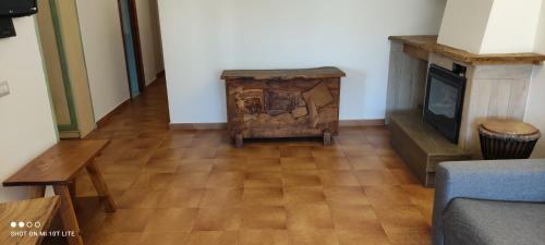 a living room with a fireplace and a wooden floor at Appartamento Cisto in Olbia