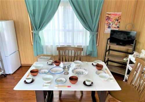 a white table with bowls and cups on top of it at Nabee no Yado B057 in Onna
