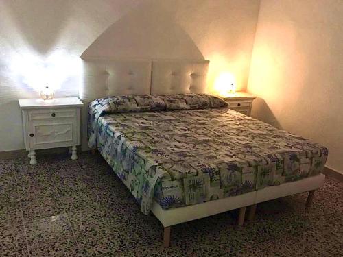 a bedroom with a bed and two night stands at Kelu e Terra - Locazione Turistica - IUN Q0467 in Onifai