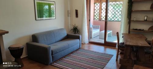 a living room with a blue couch and a table at Appartamento Cisto in Olbia