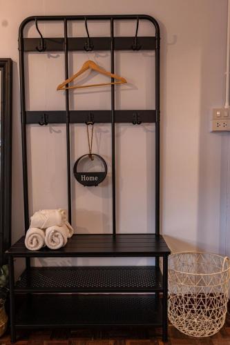 a black shelf with towels and a hanger at A Day Villa Chiangmai in Chiang Mai
