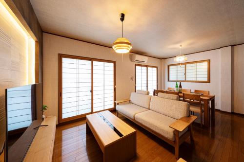 sala de estar con sofá y mesa en Shirakabanoyado - Ryogetsu, en Osaka