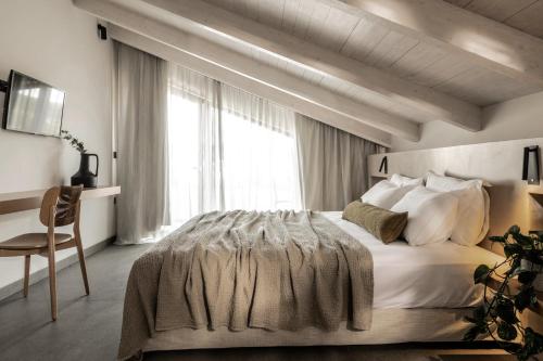 a bedroom with a large bed and a window at Dannas Boutique Hotel & Suites in Tsilivi