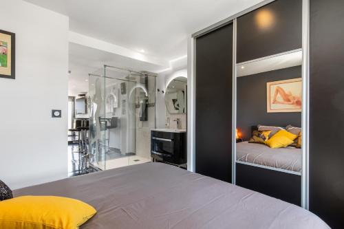 1 dormitorio con 1 cama con una gran pared de cristal en Village Naturiste R4N - Cap Caline Port Nature Coursive Luxe en Cap d'Agde