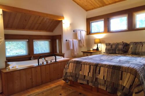 a bedroom with a bed and a bath tub at Moon Dance Cabin in Madeira Park