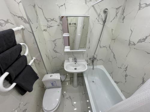 La salle de bains est pourvue d'un lavabo, de toilettes et d'une baignoire. dans l'établissement Стильная квартира с кондиционером, à Petropavlovsk-Kamtchatski