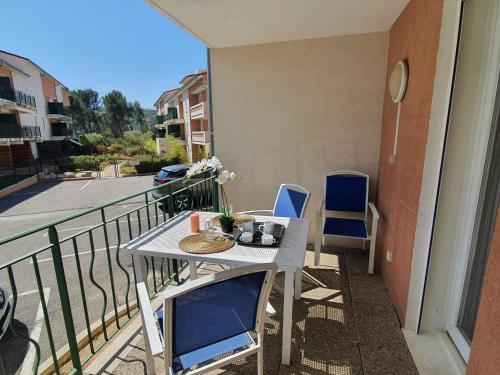 - une table et des chaises sur le balcon d'un appartement dans l'établissement L'Arbousier - Piscine & climatisation, à Gréoux-les-Bains
