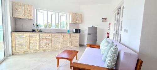 uma cozinha com um banco e uma mesa num quarto em Harmony Self-Catering Apartments em Beau Vallon