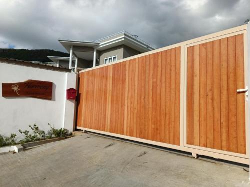 a wooden fence in front of a house at Harmony Self-Catering Apartments in Beau Vallon