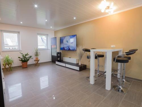 Habitación con mesa, sillas y TV. en Ferienhaus am Mühlenpfad, en Ottweiler