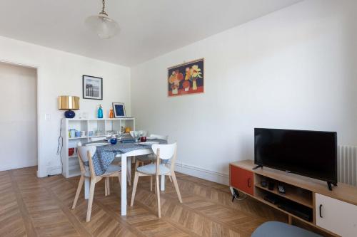 une salle à manger avec une table et une télévision dans l'établissement Lumineux 70m cosy à proximité de la plage, à Arcachon