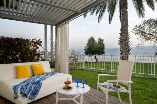 a bed and a table and a chair on a patio at Ein Gev Holiday Resort in En Gev
