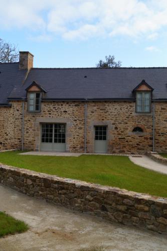 a stone house with a stone wall at Les Terrasses de La Moglais in Lamballe