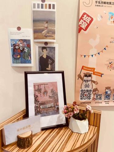a picture frame on a wooden table with pictures and posters at Fuzhongju Homestay in Jincheng