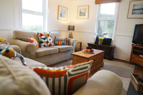 a living room with two couches and a tv at Tamarisk, Port Isaac Bay Holidays in Port Isaac