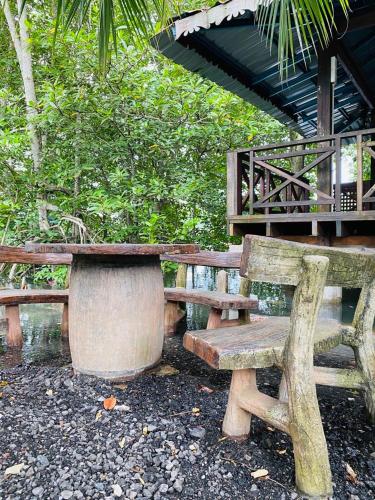 a wooden bench sitting next to a building at Homestay Cikgu Sungai Batu Besi in Bedung