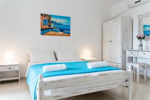 a white bedroom with a bed and two tables at Villa Kallithea in Parga