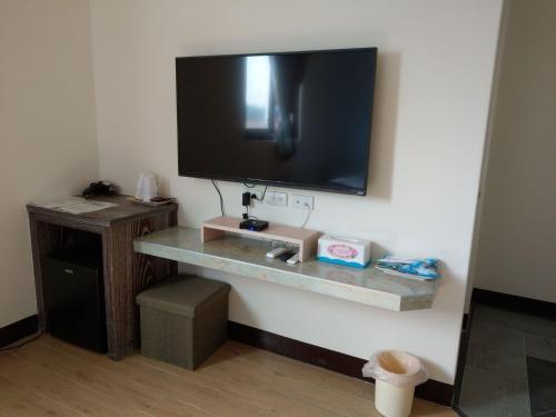 a flat screen tv hanging on a wall at Fuzhongju Homestay in Jincheng