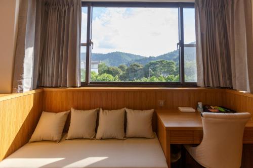 a room with a desk and a window with a bench at 埔里夏都華蔓山林日式會館 Puli Huaman Villa in Puli