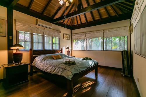 a bedroom with a bed in a room with windows at Elysia Nongsa 24 Batam Luxury Villa in Nongsa