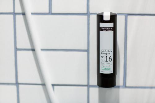 a bottle of liquid on a white tiled wall at Hôtel Névé in Morzine