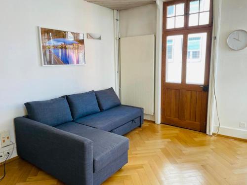 Sofá azul en una sala de estar con puerta en Apartment Marktplatz 2, en Basilea