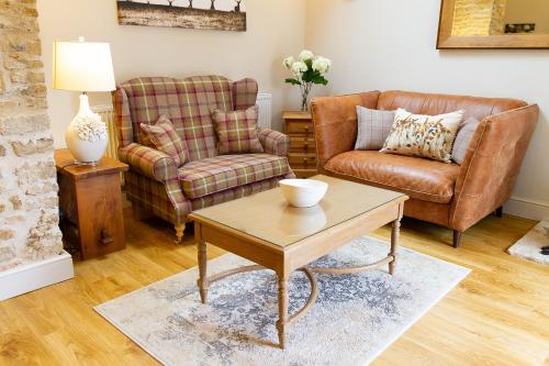 a living room with two chairs and a coffee table at The Little Bothy in Wansford