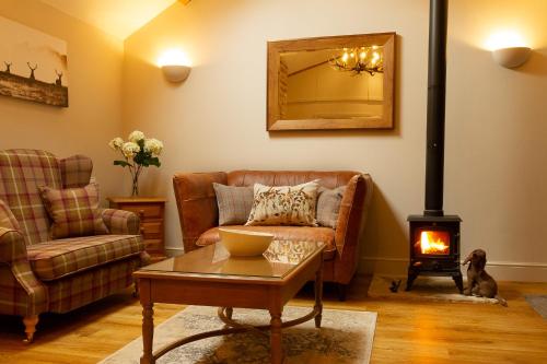 a living room with a couch and a wood stove at Luxury Barn near Stamford in Wansford