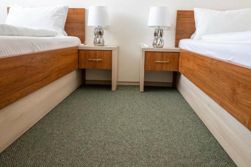 two beds in a room with two lamps on tables at Tišnovská Rychta in Tišnov