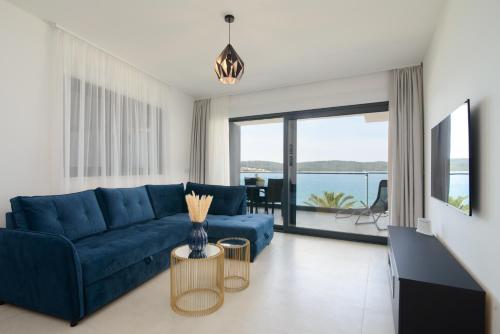 a living room with a blue couch and a view of the ocean at Ero on the beach in Trogir