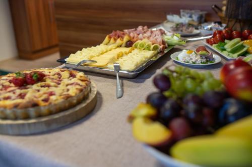 a buffet with pizzas and fruit on a table at Tišnovská Rychta in Tišnov