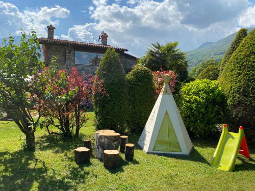 a garden with a play tent in the grass at Casa Cinzia in Gravedona