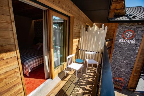 a balcony with two chairs and a bedroom at Hôtel Névé in Morzine