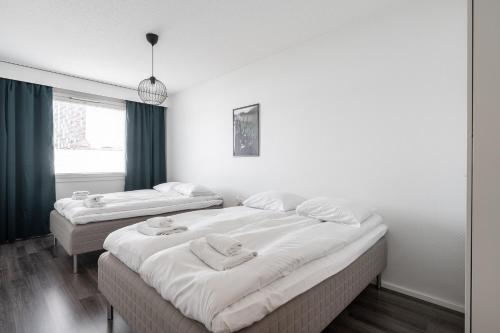 two beds in a room with white walls at 2ndhomes Tampere "Otavala" Apartment - Just Renovated - Hosts 8 in Tampere