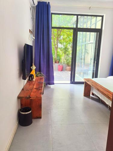 a bedroom with a tv and a sliding glass door at Tujia folk houses in Zhangjiajie