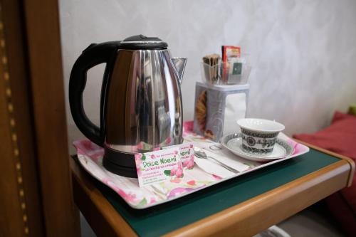 einen Wasserkocher und eine Tasse auf dem Tisch in der Unterkunft Bed and Breakfast Dolce Noemi in Reggio di Calabria