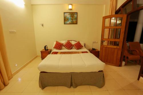 a bedroom with a large bed with red pillows at The Sanctum Spring Beach Resort in Varkala