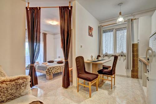 a kitchen and dining room with a table and chairs at Apartments Kajfes in Fažana