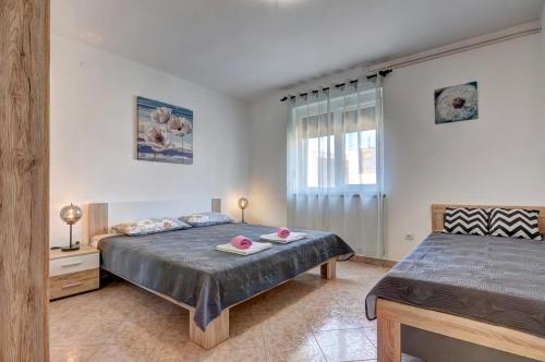 a bedroom with two beds and a window at Apartments Kajfes in Fažana